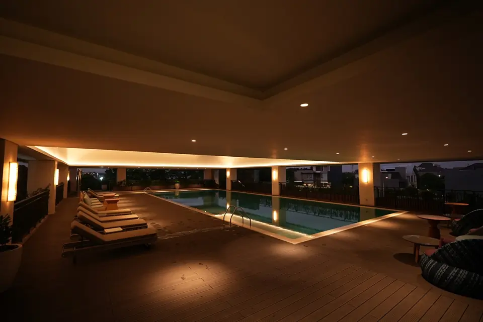 Kolam renang indoor rooftop dengan pencahayaan malam